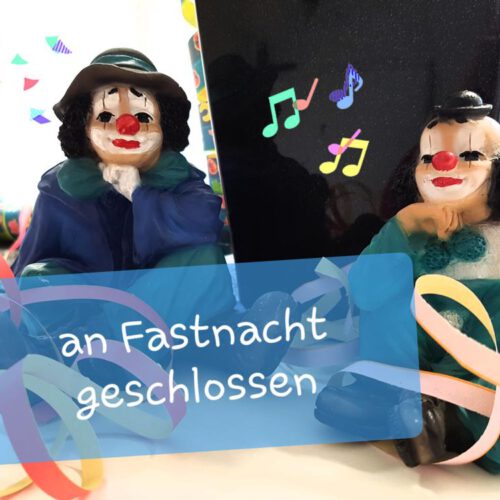 Zwei Keramik-Clowns sitzen auf einem Tisch. Ein Hinweis mit der Aufschrift An Fastnacht geschlossen steht in der Mitte.