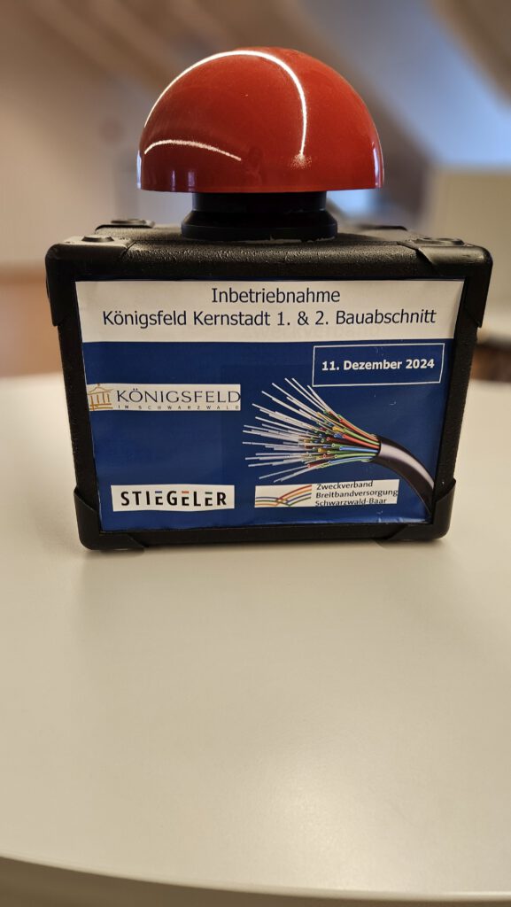 Ein Buzzer mit dem Schild für die Inbetriebnahme des 1. und 2. Bauabschnittes in Königsfeld