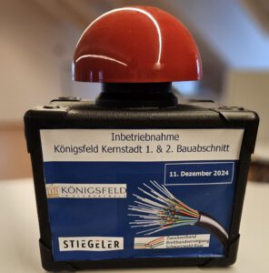 Ein Buzzer mit dem Schild für die Inbetriebnahme des 1. und 2. Bauabschnittes in Königsfeld