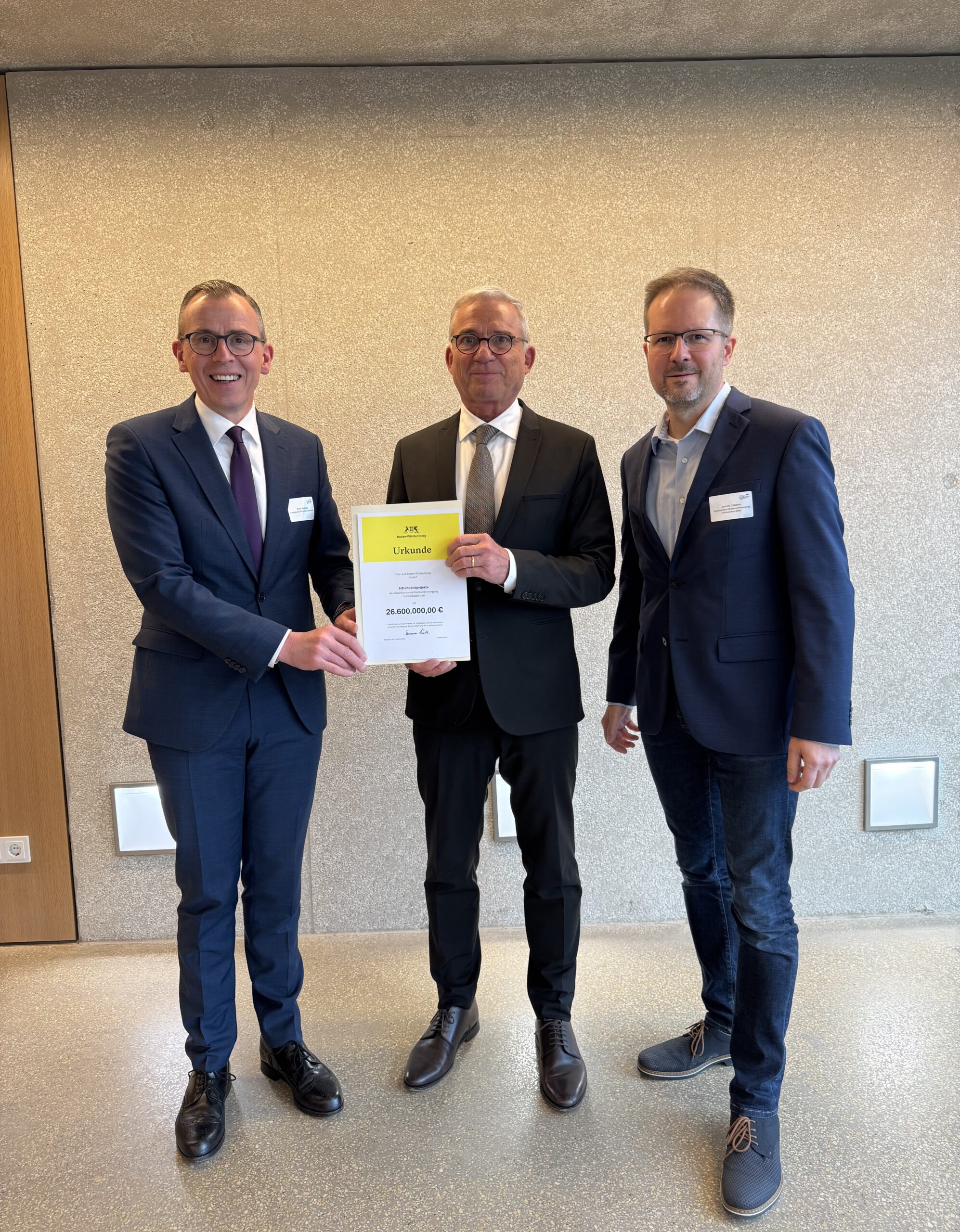 Digitalminister Strobl übergibt einen Förderbescheid an Landrat Sven HInterseh und Geschäftsführer Jochen Cabanis